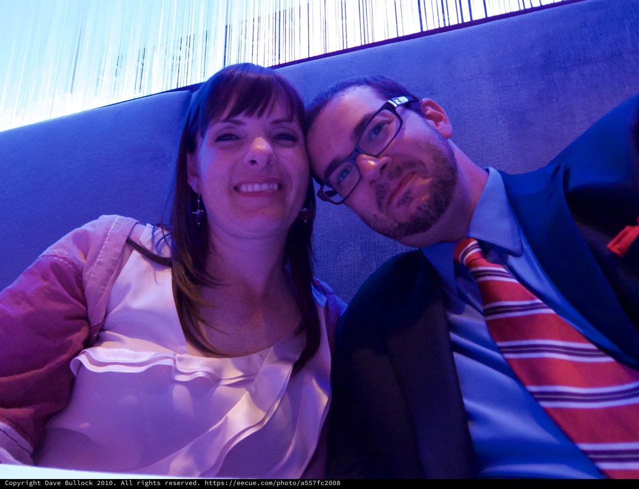 Couple Poses Together in Blue-Lit Lounge