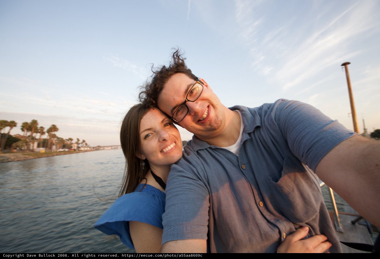 Couple's Joyful Selfie at Golden Hour Waterway