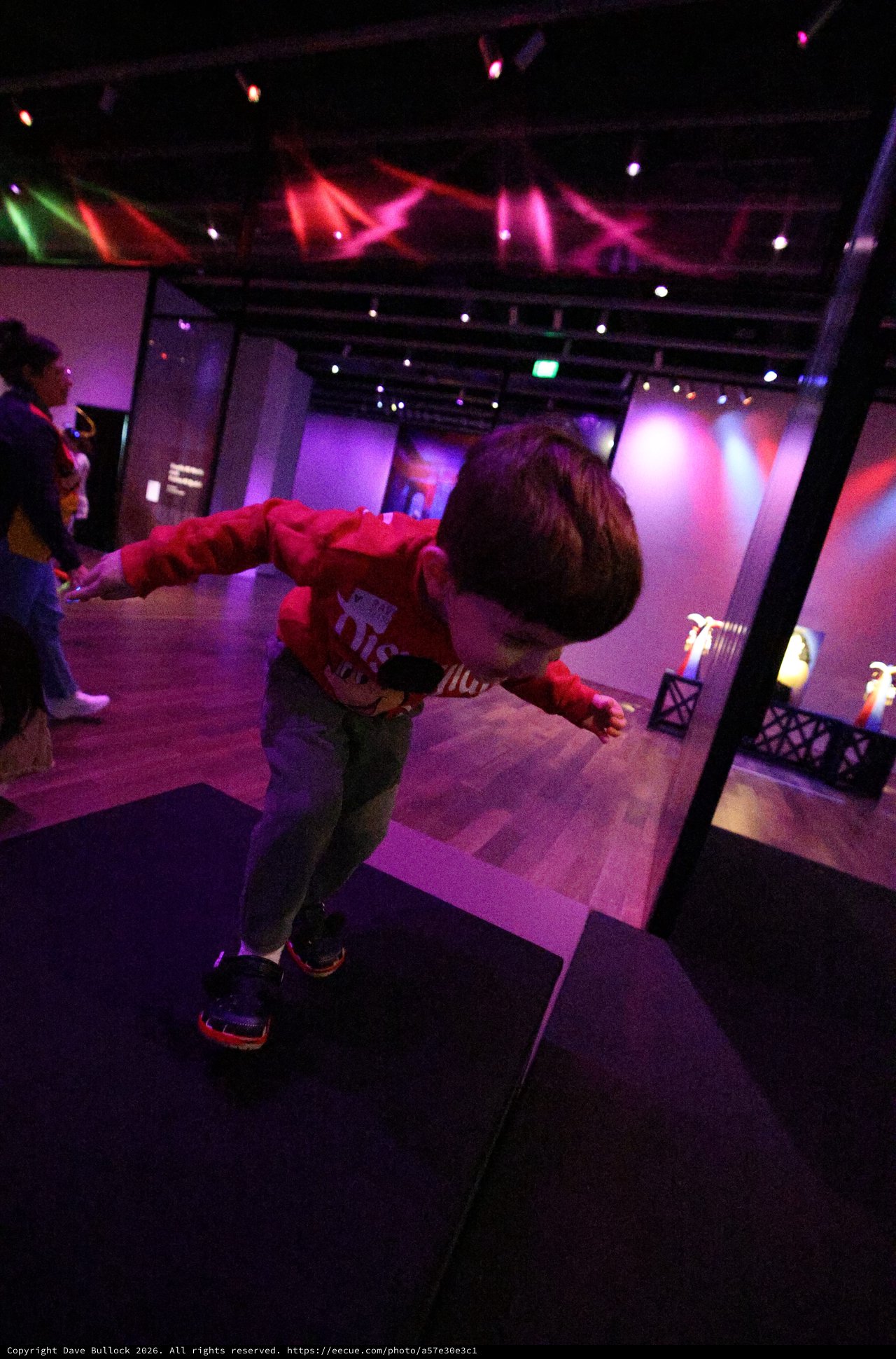 Child Dancing at Baby Rave Event Under Colorful Lights
