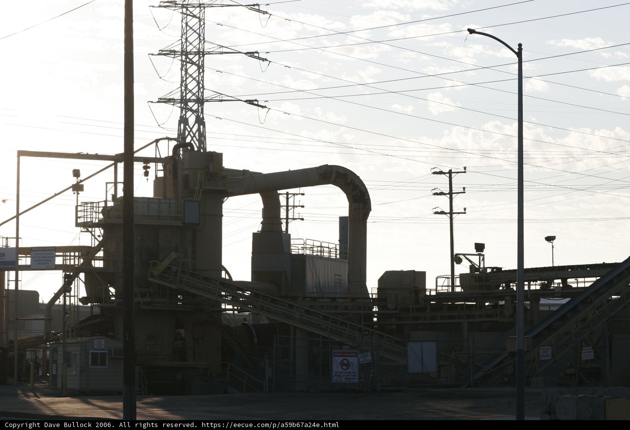 Towering Factory Amidst a Web of Power Lines