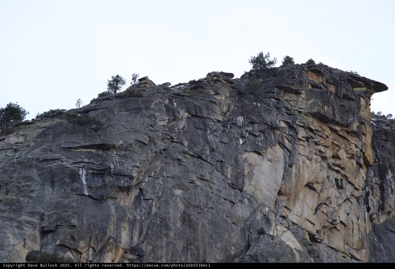 Dramatic Layered Rock Face with Overhanging Cliff Edge