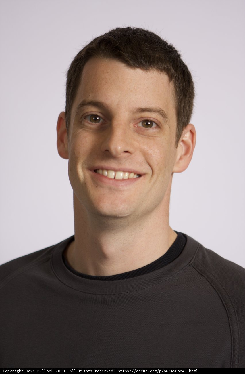 Black Shirted Man Smiling for the Camera