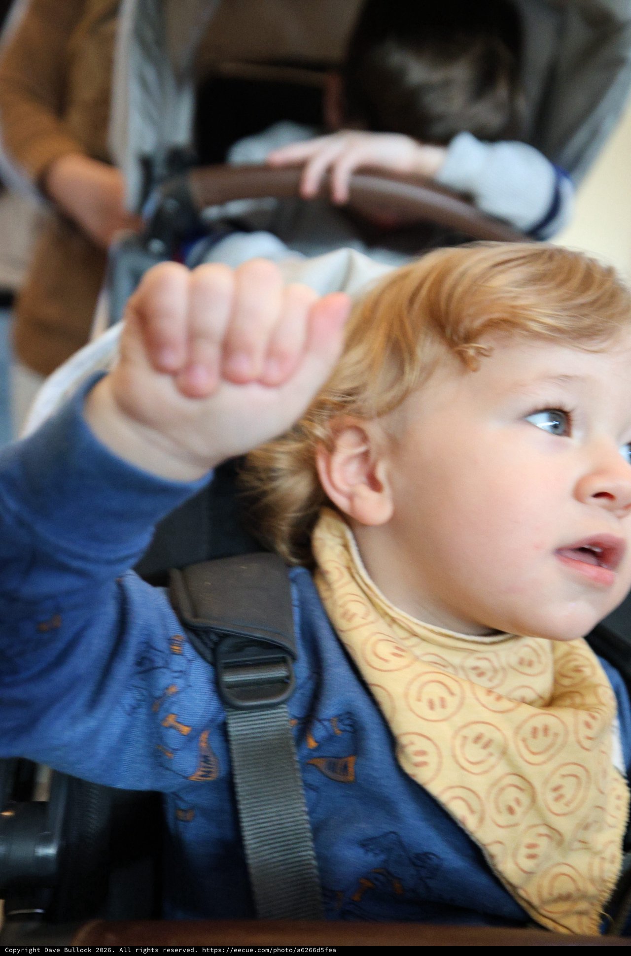 Young Child Waving from Car Seat During Road Trip