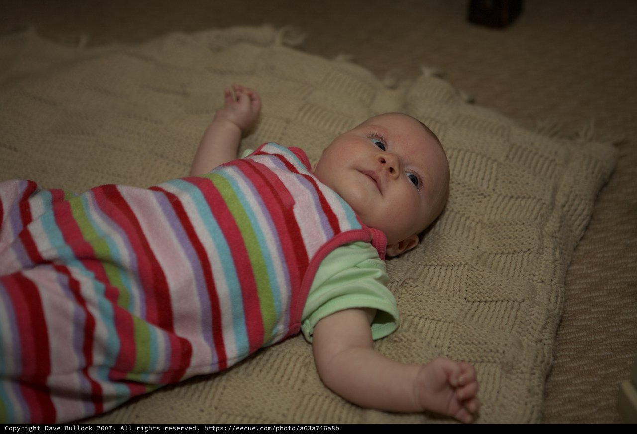 Curious Infant Gazing Upward on Knit Blanket