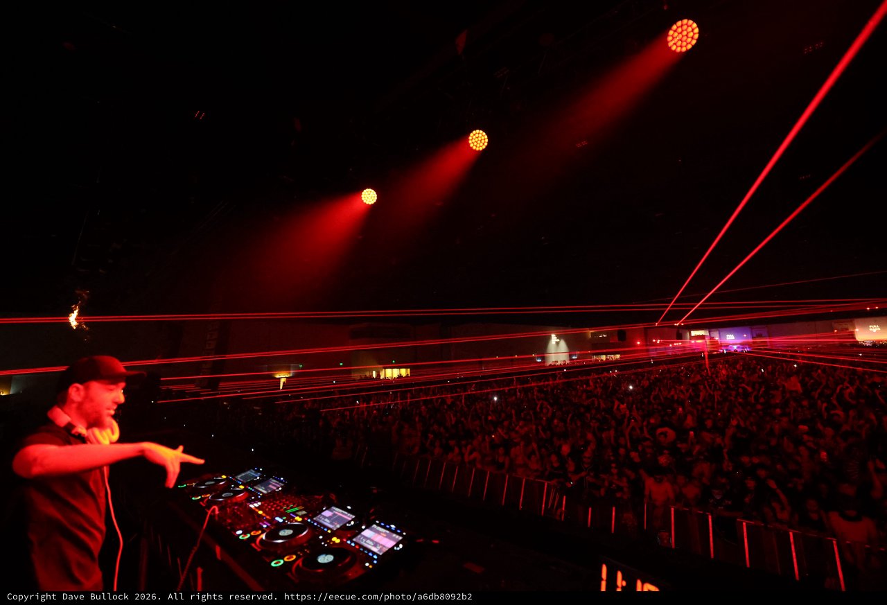 DJ Commands Massive Crowd Under Red Laser Storm