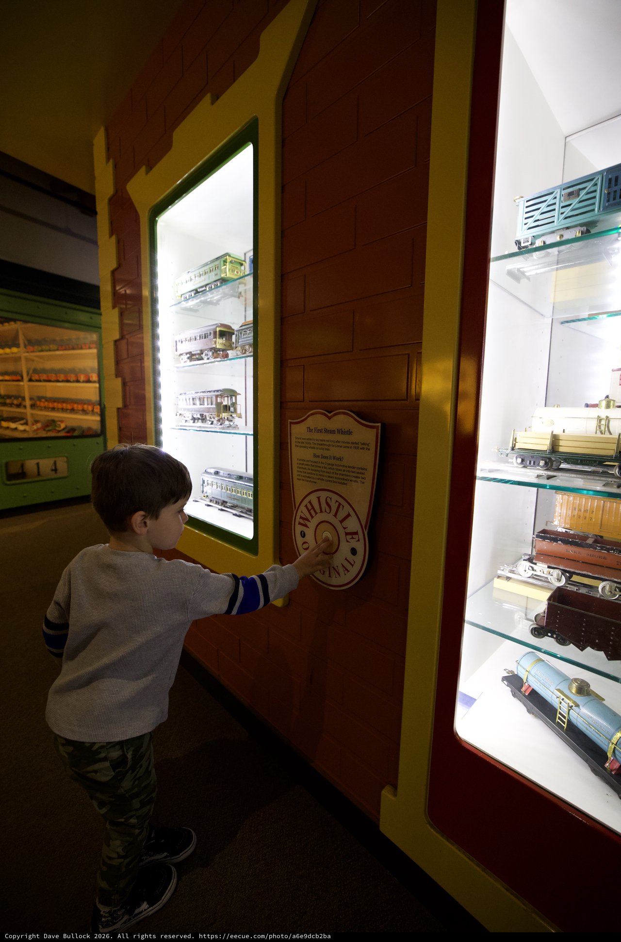 Young Boy Explores Interactive Train Whistle Exhibit at Museum
