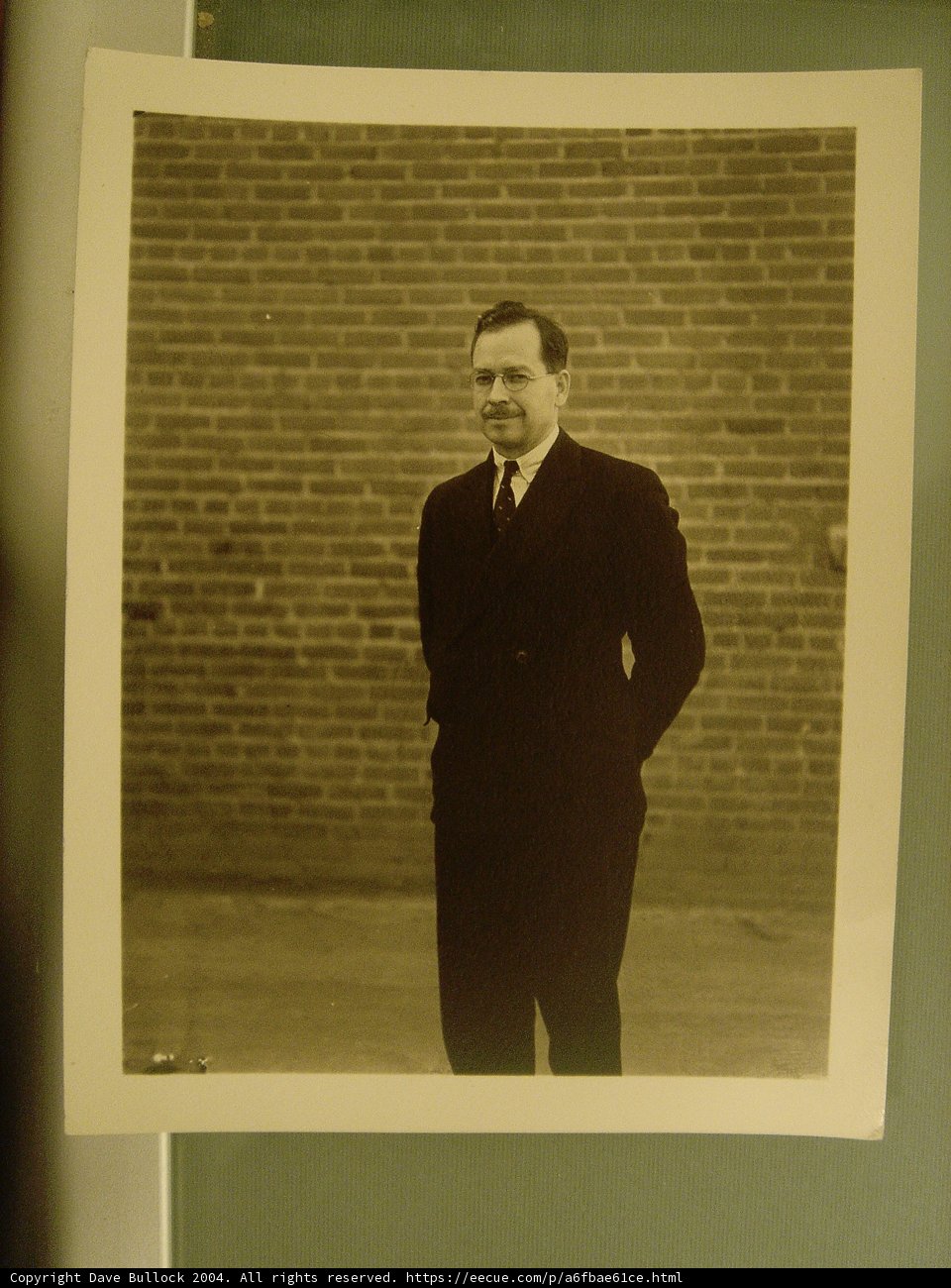Businessman posing in front of brick wall