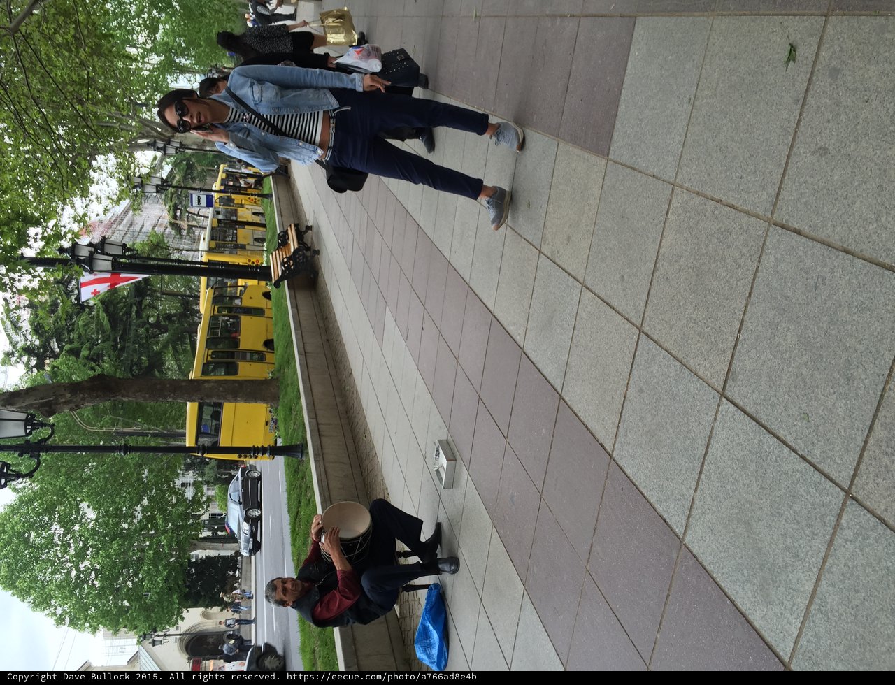 Street Musician and Passerby on Tbilisi Boulevard