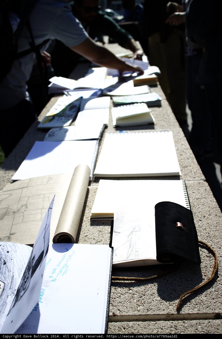 Man Examining Documents and Leather Bag on Table
