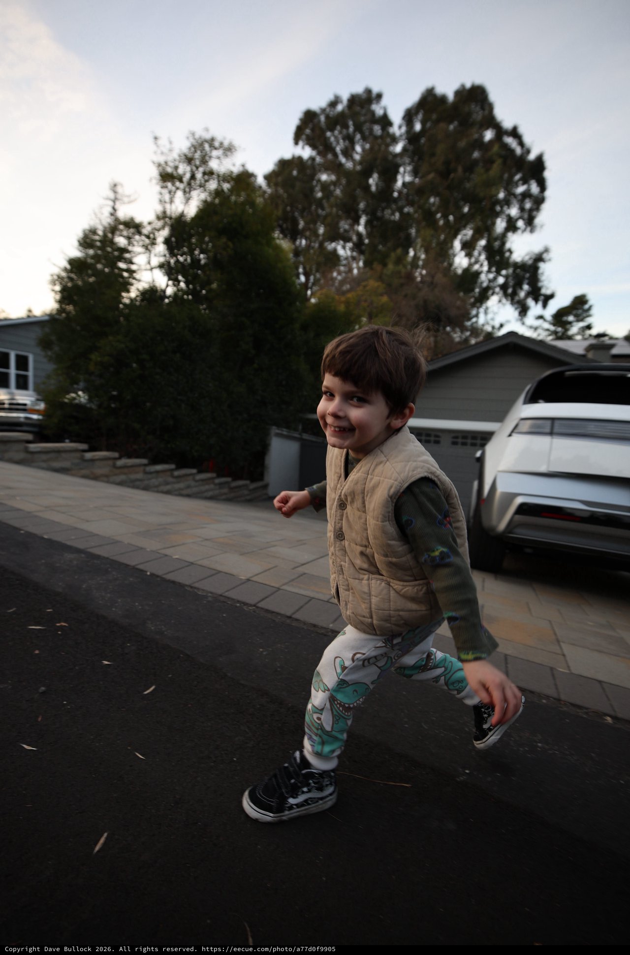 Joyful Child Playing in Suburban Driveway at Dusk
