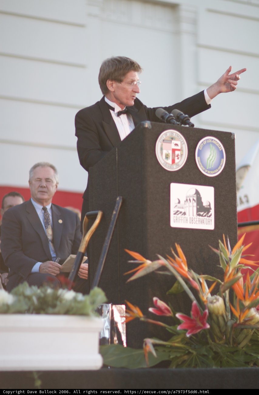 Man in Suit Delivering an Address in Front of a Crowd