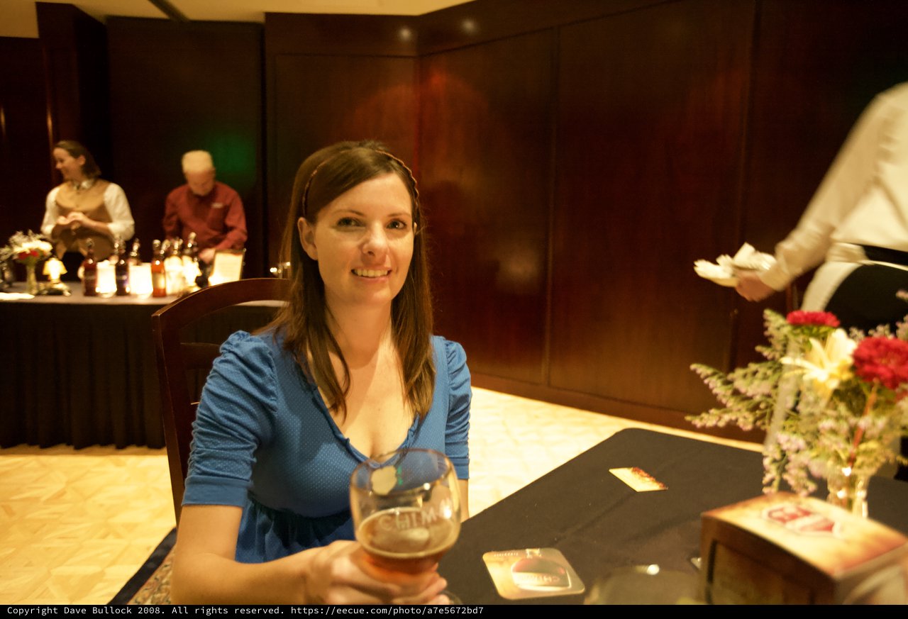 Penelope Smiling with Chimay Beer at Elegant Event