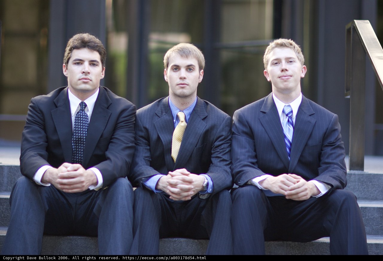 Three Men in Suits Take a Group Shot on Stairs