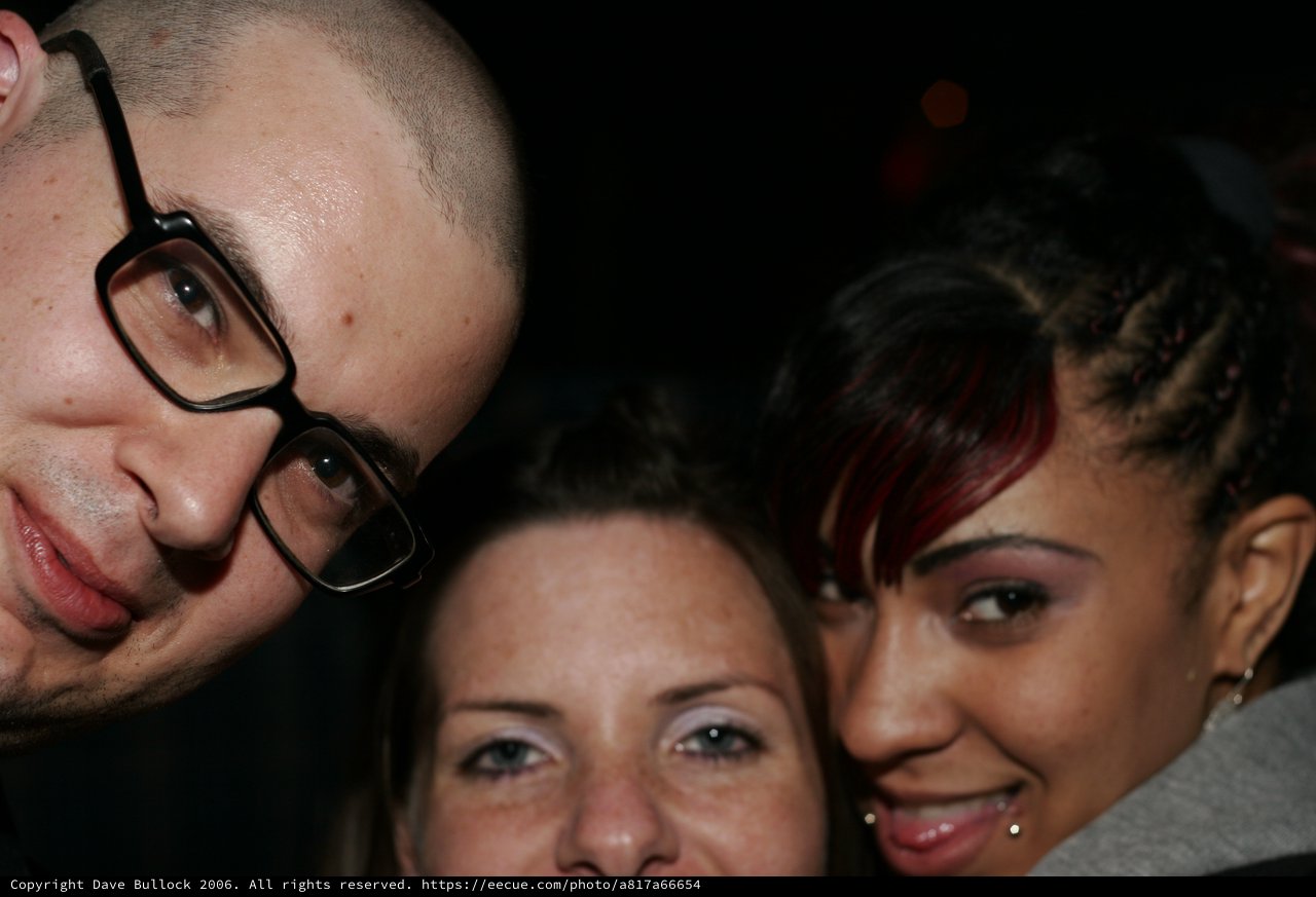 Three Friends Posing Together at a Nighttime Event