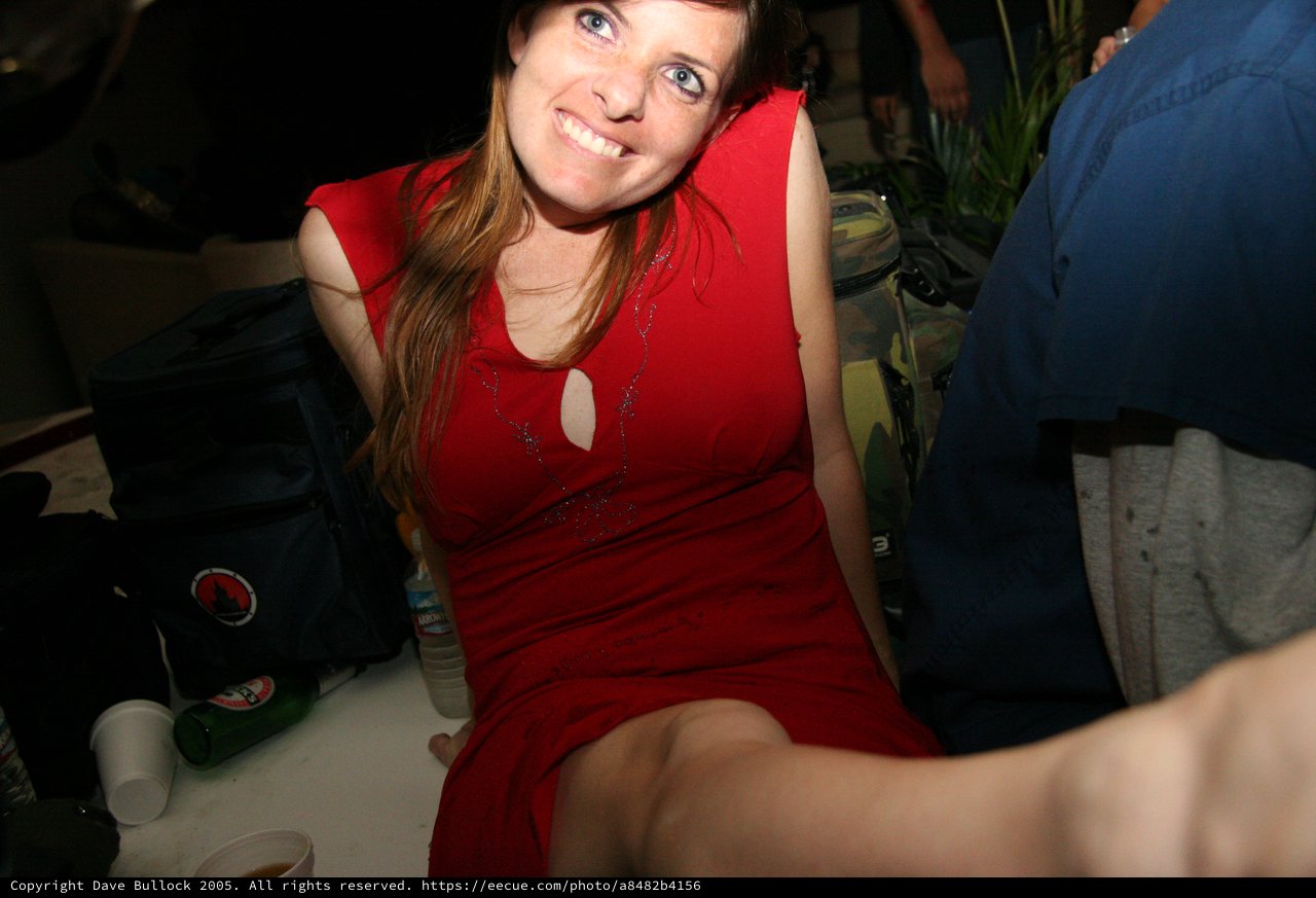 Smiling Woman in Red Dress at Indoor Party