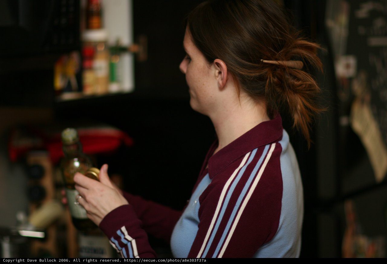 Woman in Vintage Adidas Jacket Opening a Jar