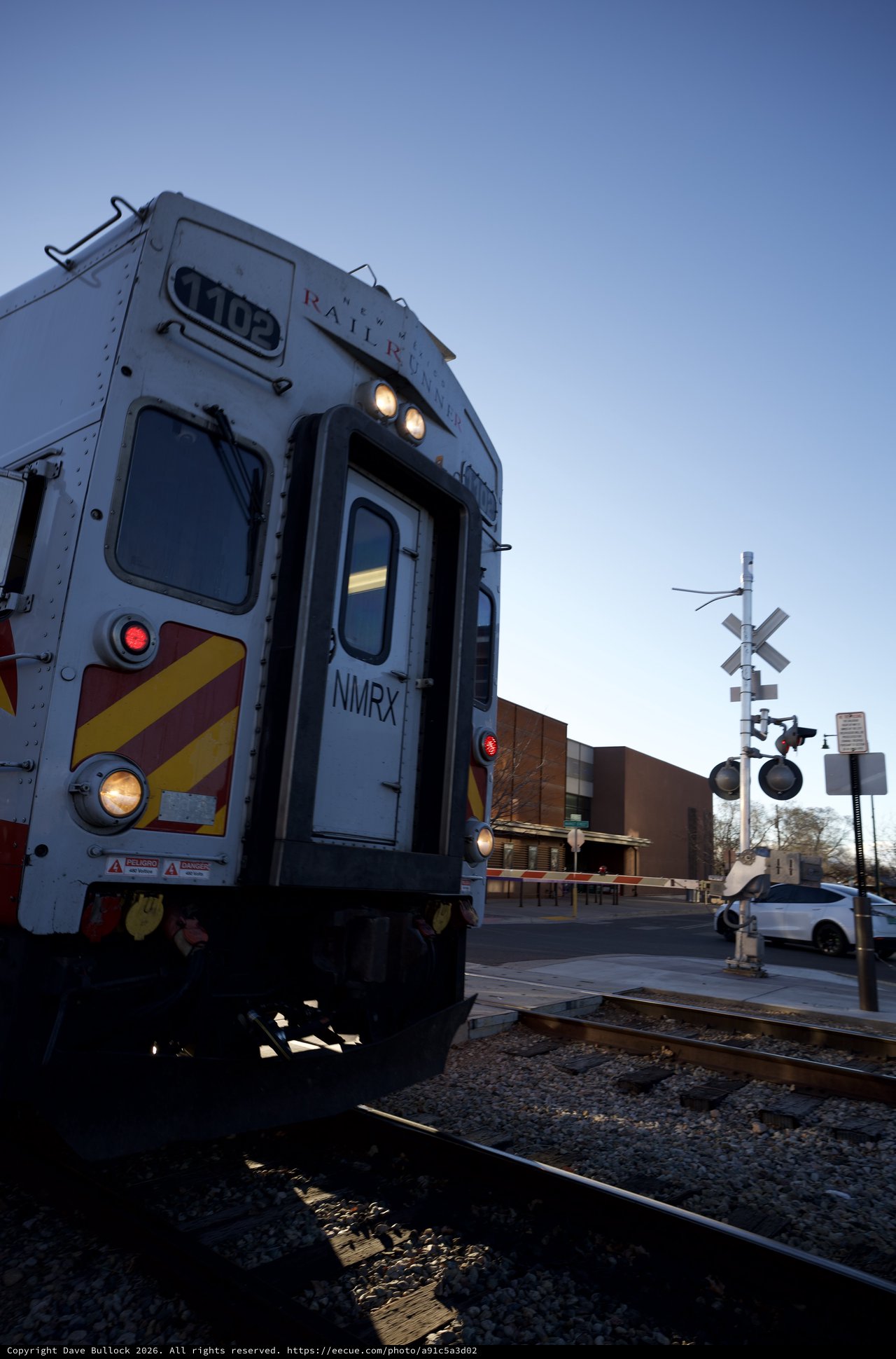 Commuter Train at Railroad Crossing During Twilight