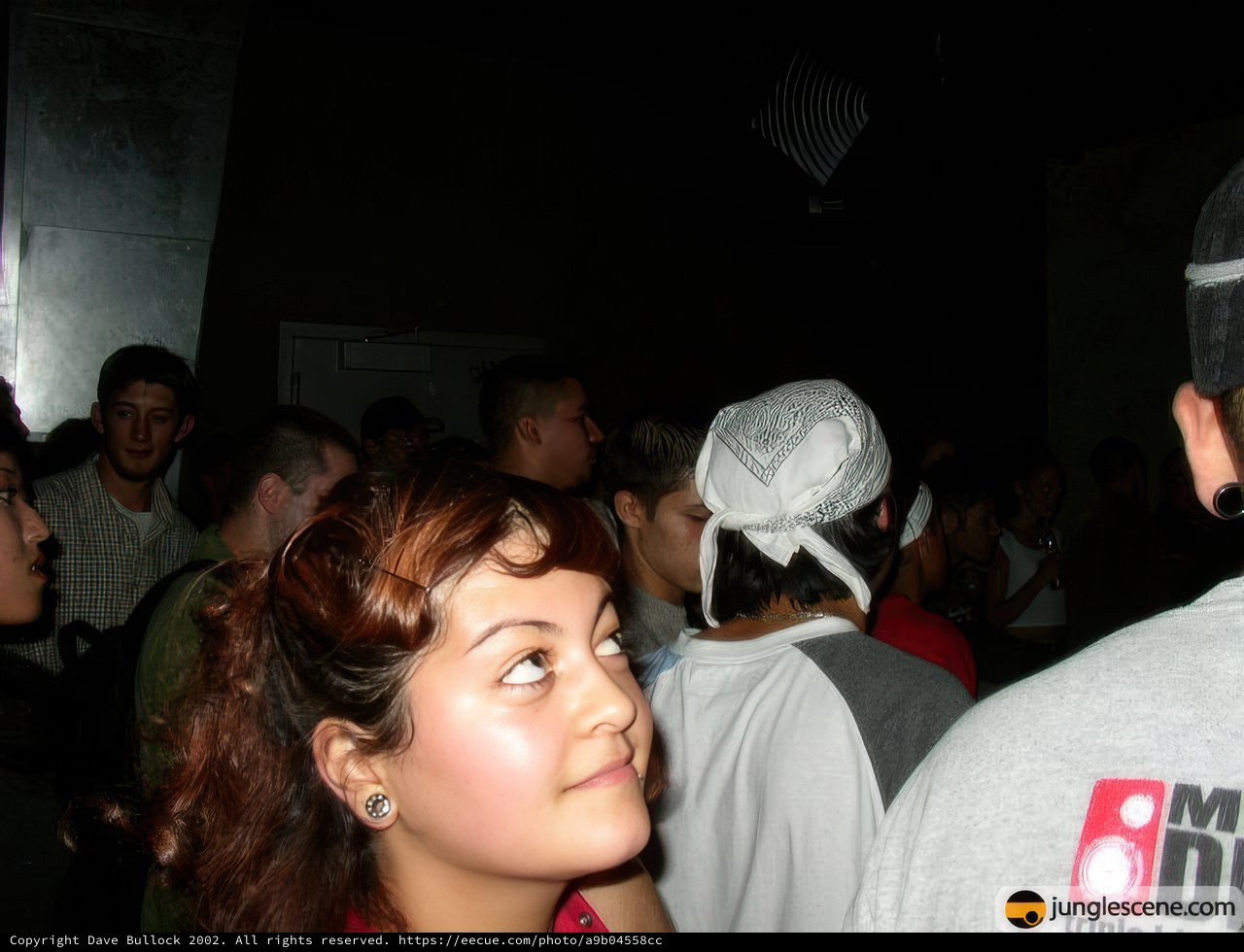 Woman in White Hat Stands Out in Crowded Room