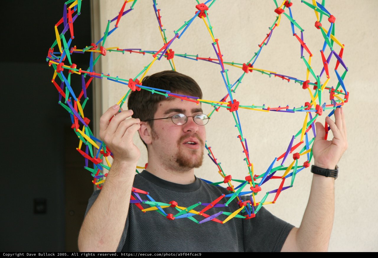 Young Man Holds Colorful K'NEX Geometric Sphere Construction