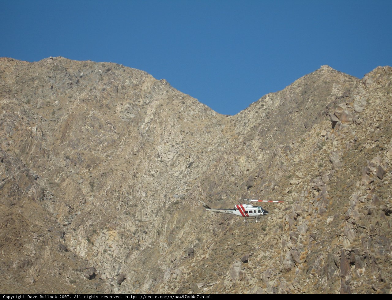 Helicopter soaring over majestic mountain range
