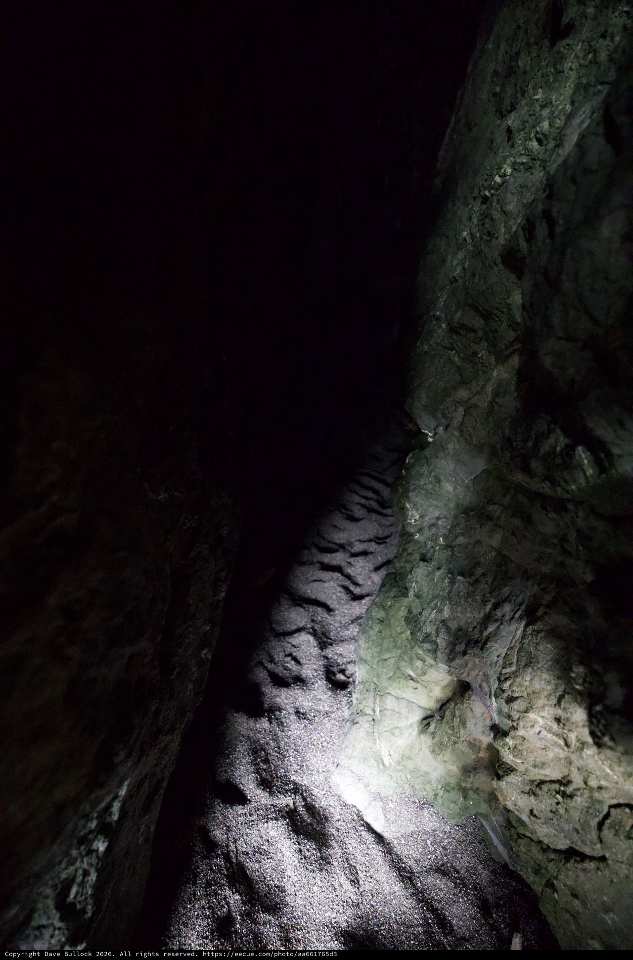Narrow Cave Passage Illuminated by Single Light