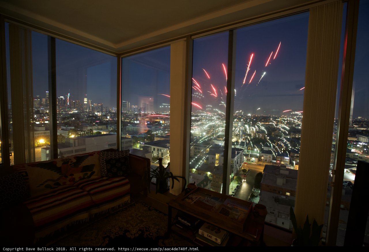 Fireworks Illuminate the City from a Living Room Window