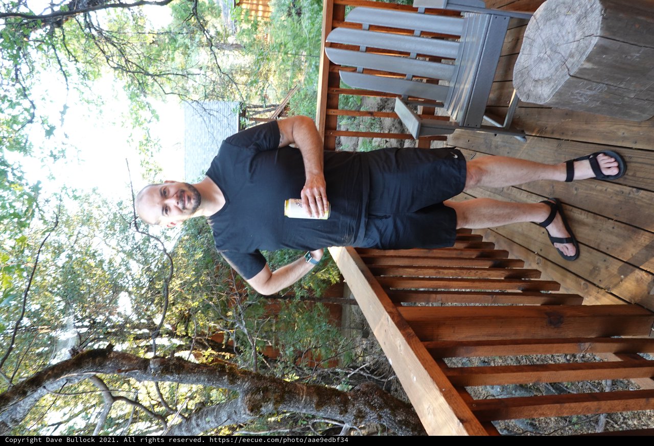 Man Relaxing on Lakeside Cabin Deck