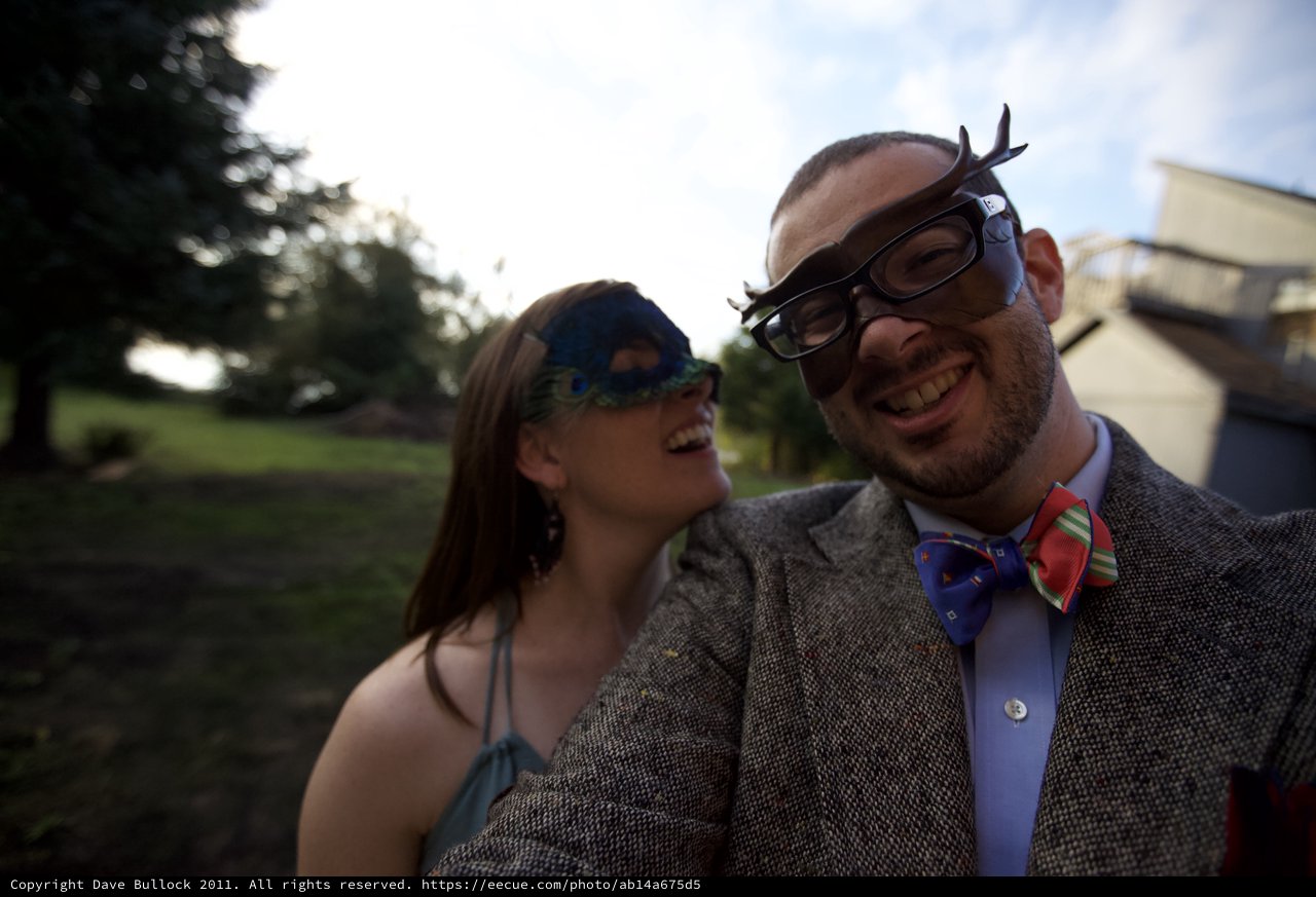 Masked Couple Laughing at Outdoor Wedding Celebration
