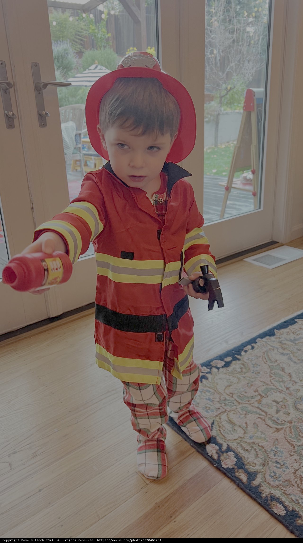 Young Child in Firefighter Costume Playing Indoors