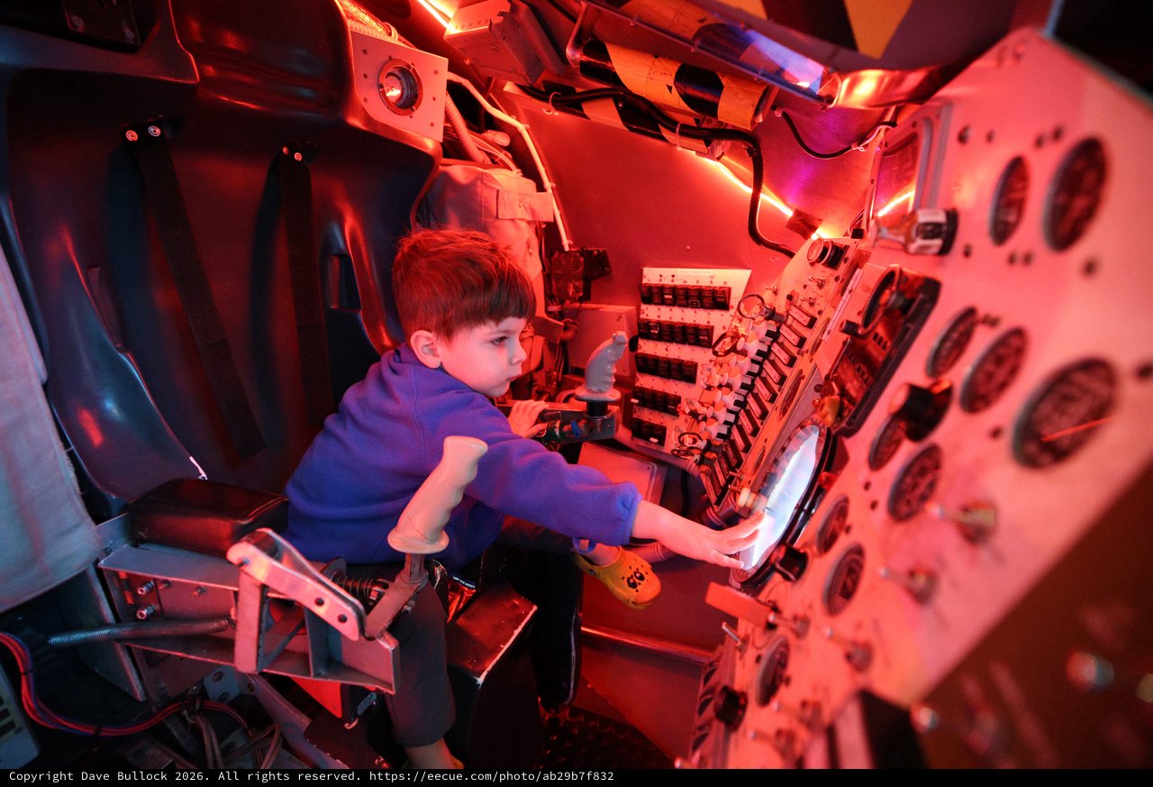 Young Visitor Explores Submarine Control Panel Exhibit