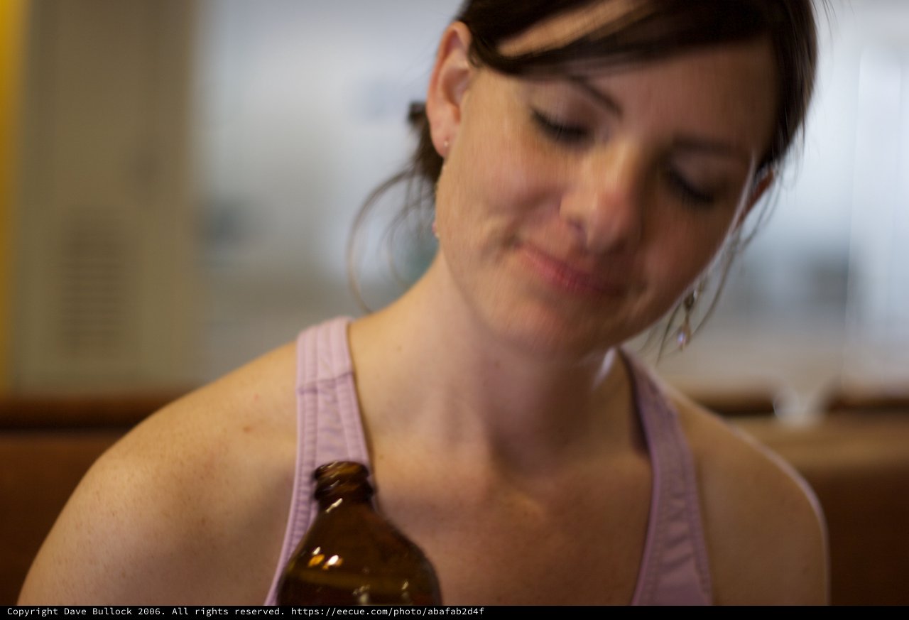 Woman with Beer Bottle in Warm Indoor Light