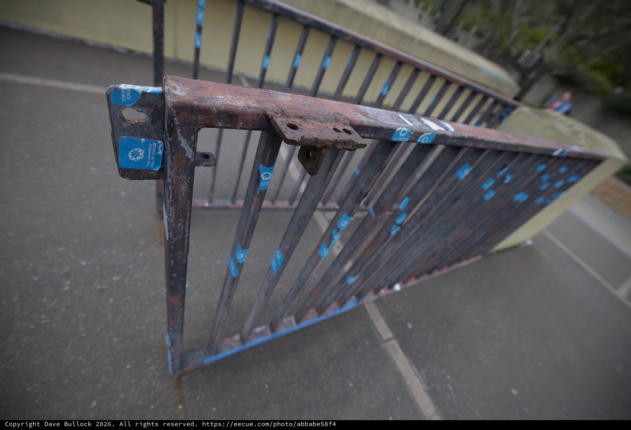 Rusted Metal Railing with Blue Accents on Urban Bridge