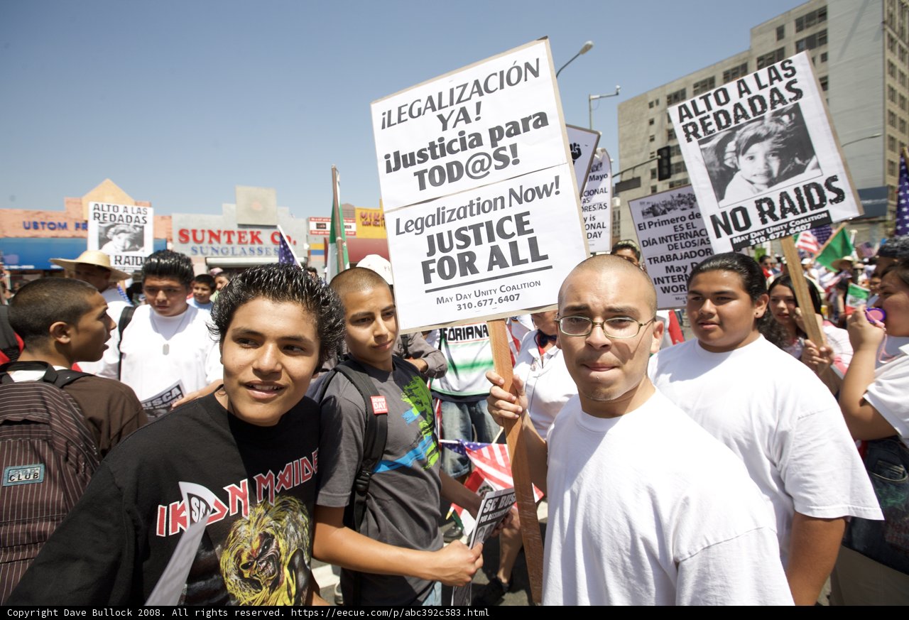 Mayday Rally Protesters Hold Up Signs Under Blue Skies