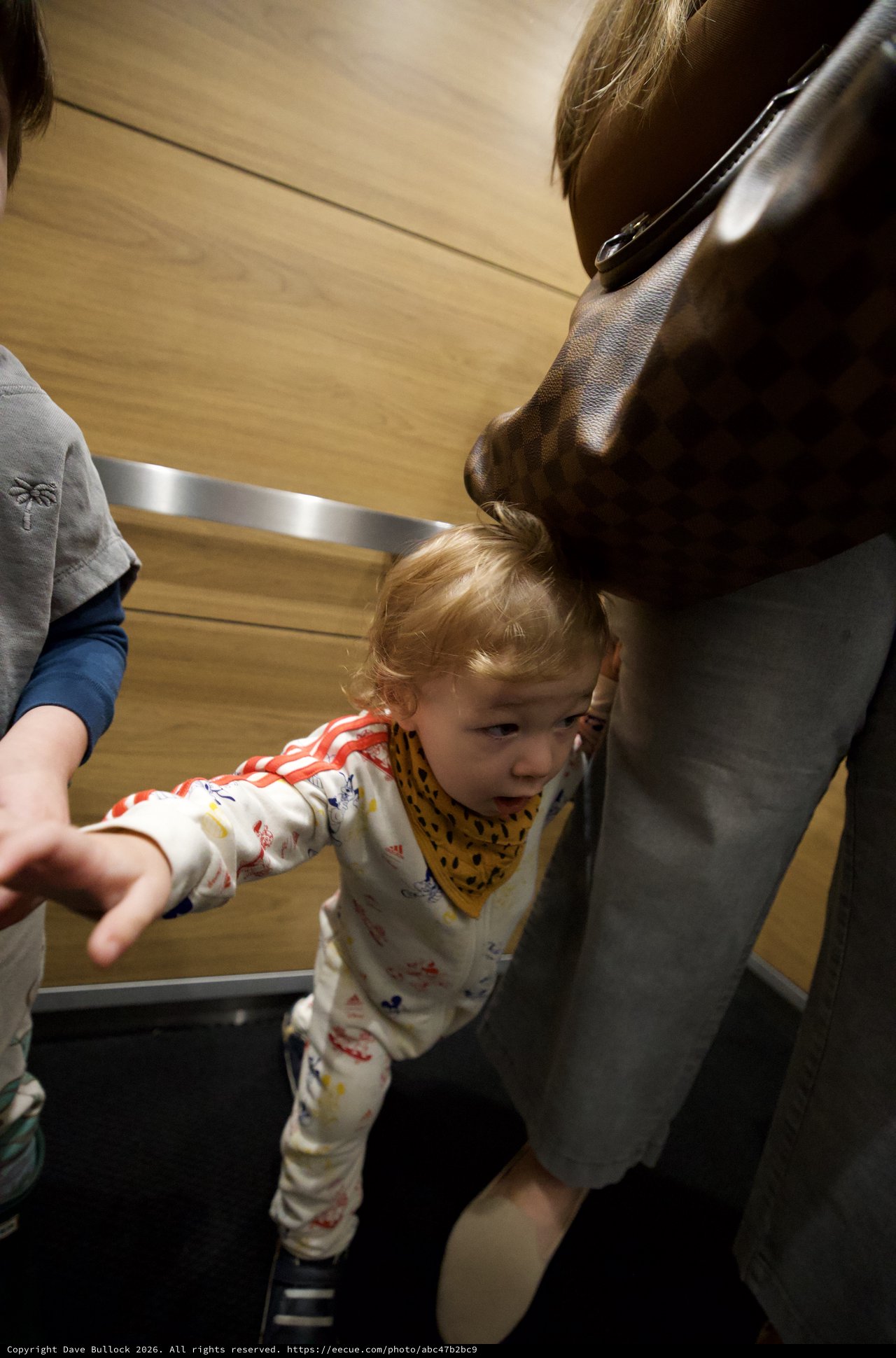 Toddler Reaching Out in Modern Elevator