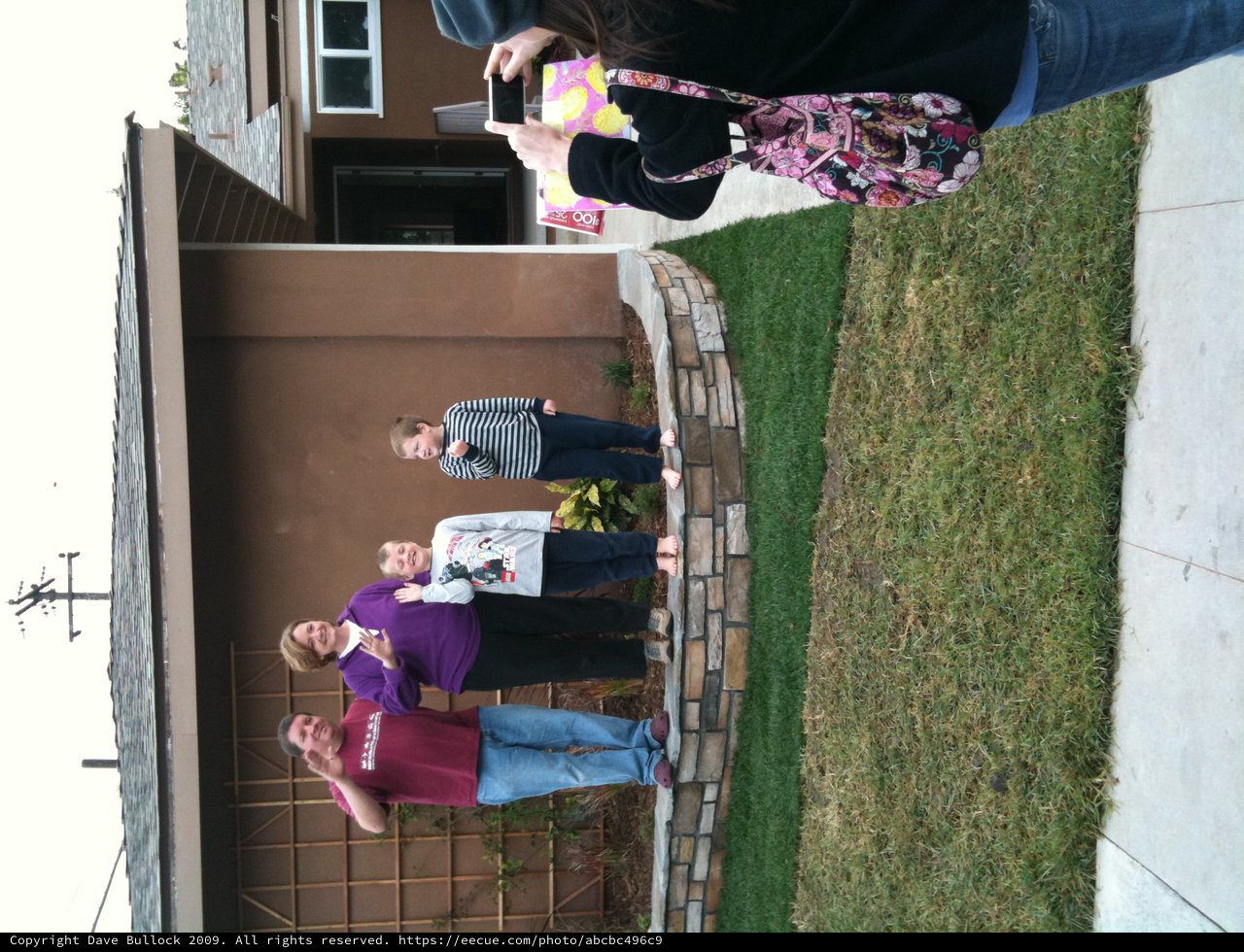 Family Waving Hello Outside Their Home