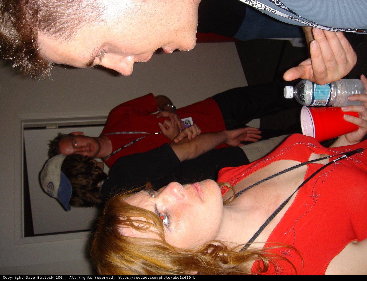 Woman in Red Looks Up at Man with Water Bottle