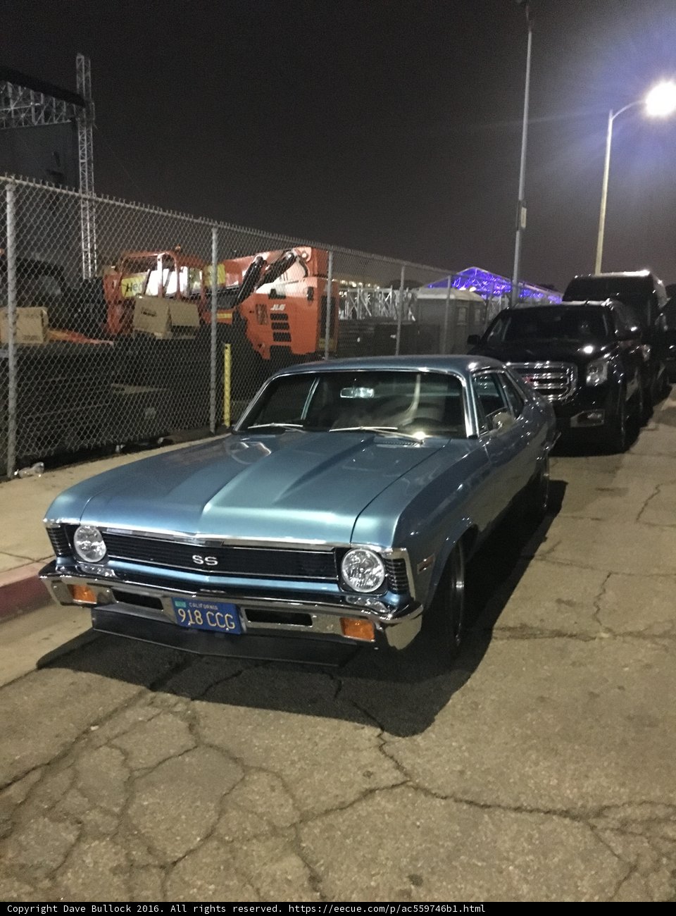 Blue Muscle Car Parked in Front of Fence
