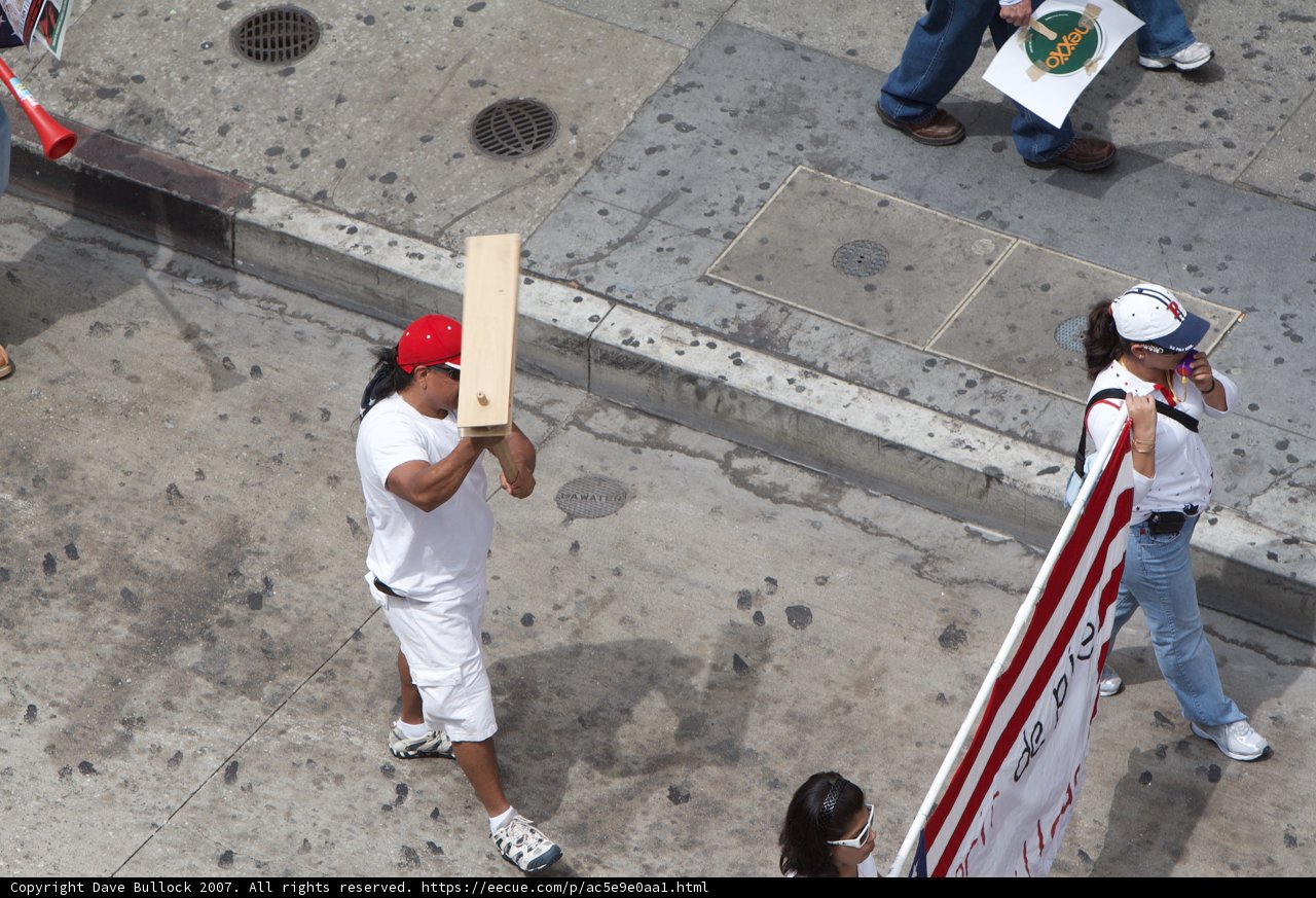 Man Carrying a Wooden Board on City Sidewalk