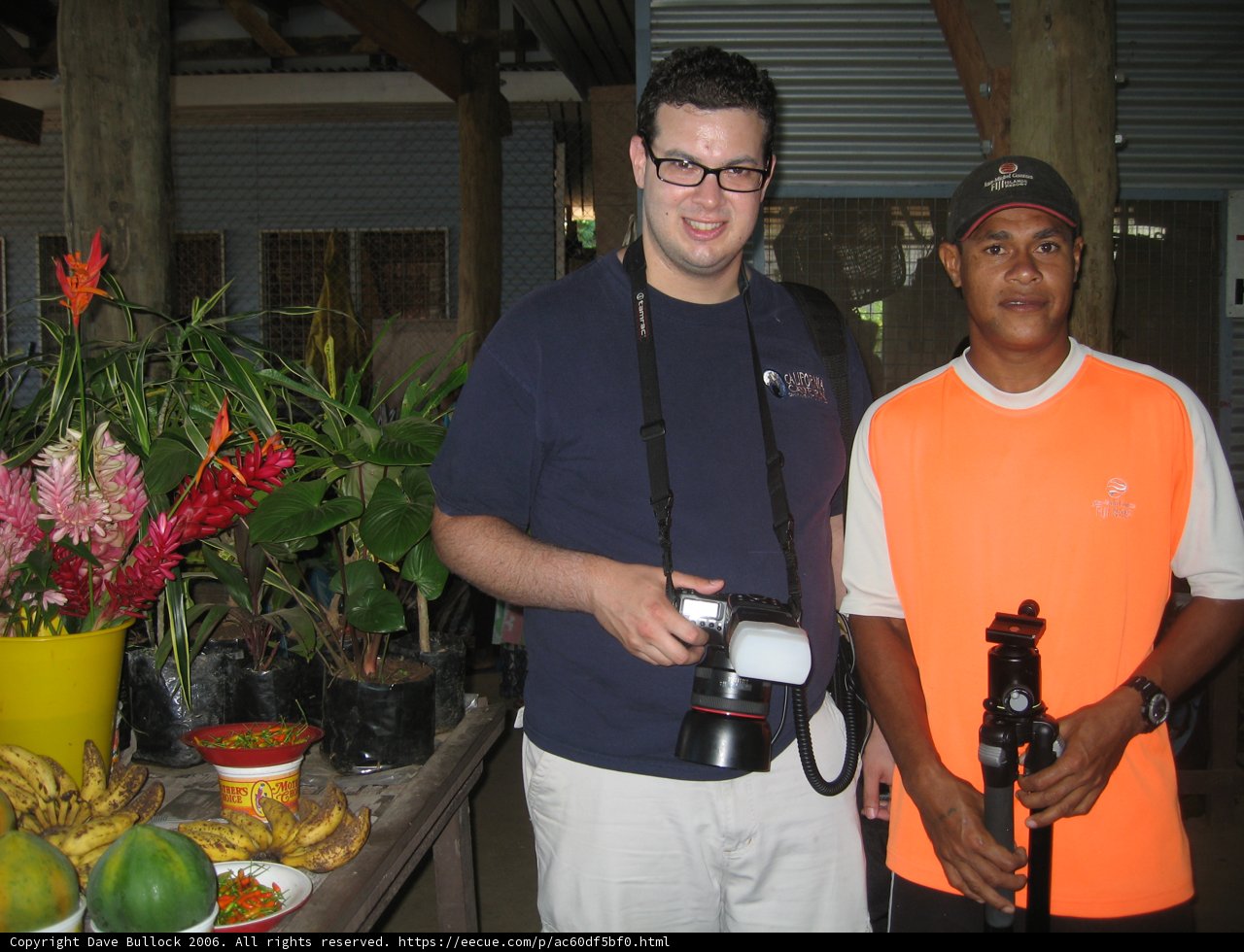 Orange-Shirted Dave B Takes a Snapshot of a Flower Arrangement