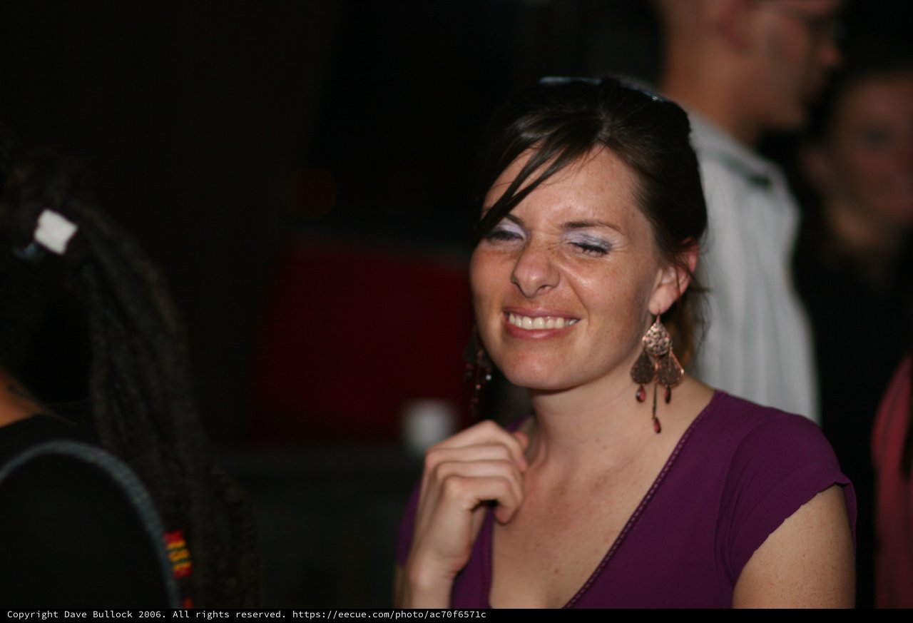 Joyful Woman Smiling at Nighttime Social Gathering
