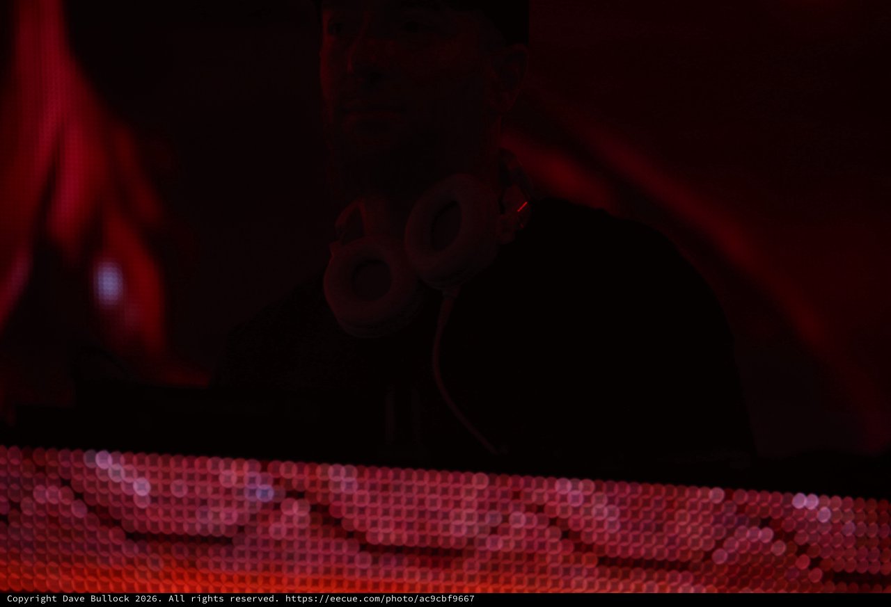 Masked DJ Performs Under Red Stage Lights
