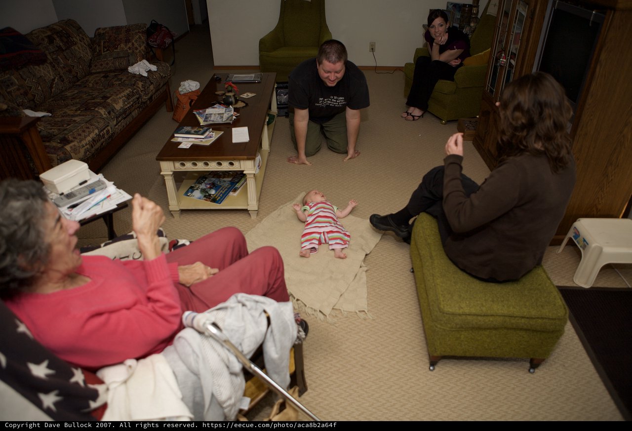 Family Gathering Around Newborn Baby on Floor