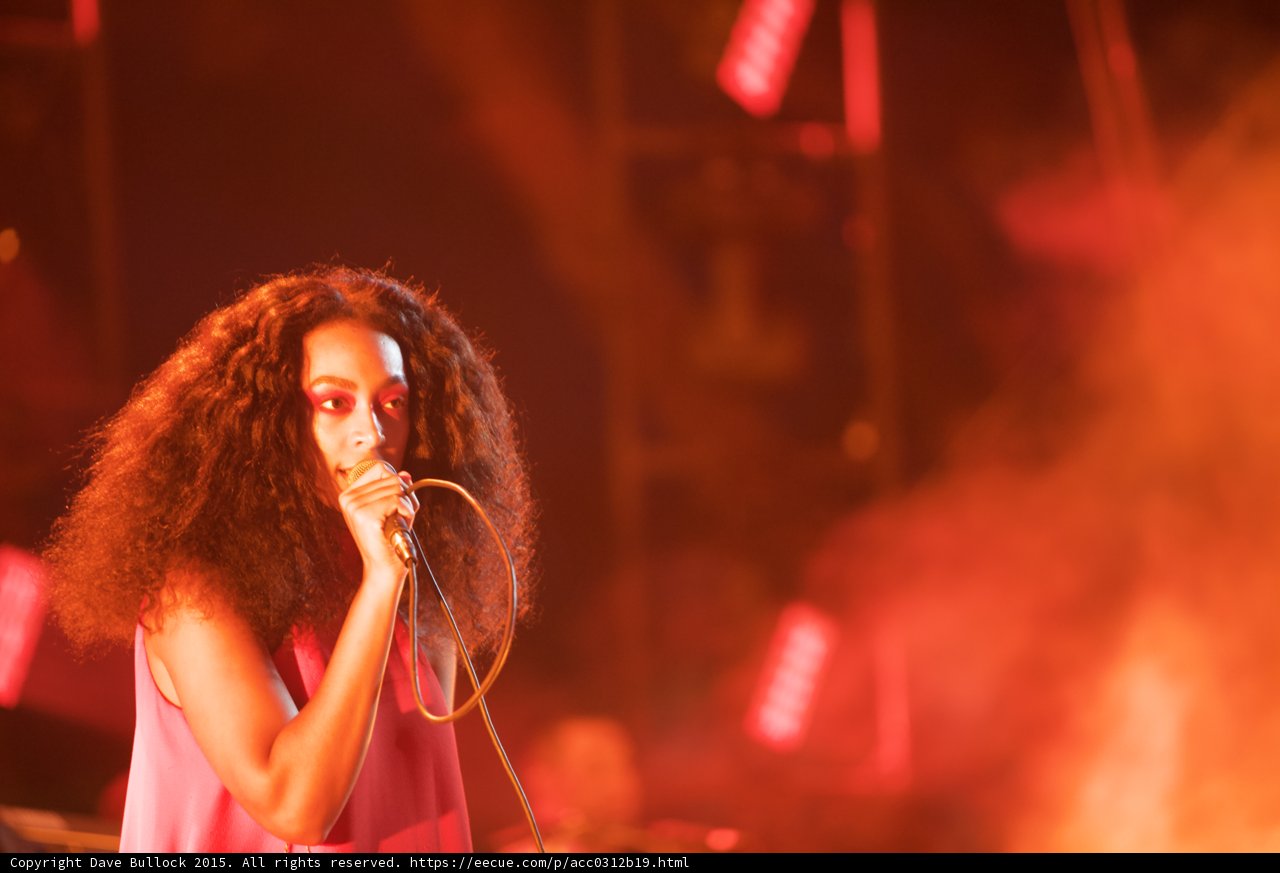 Solange Portrait Looking Forward Red Orange Smoke Stage Lights