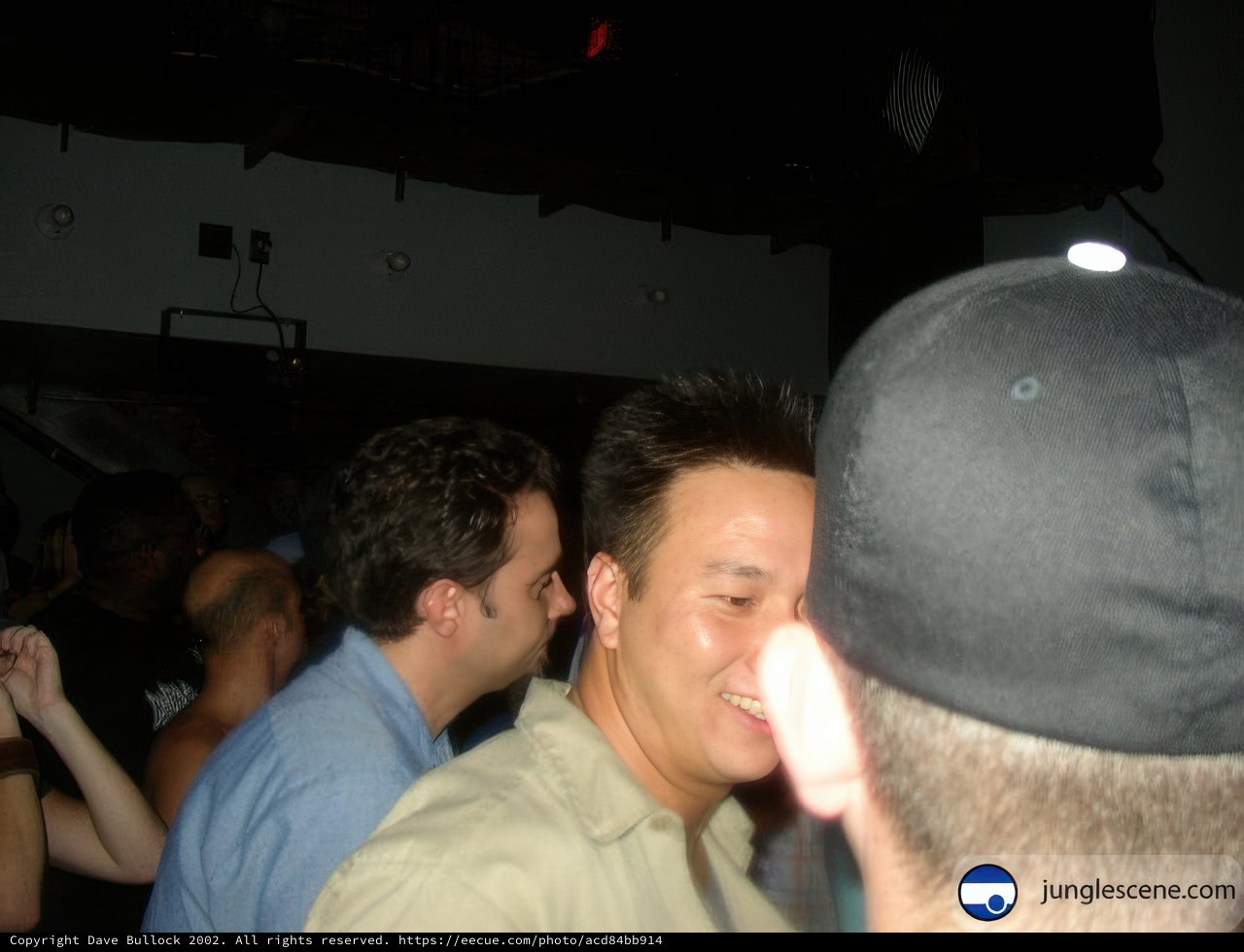 Smiling Man in Baseball Cap Captivates Crowd