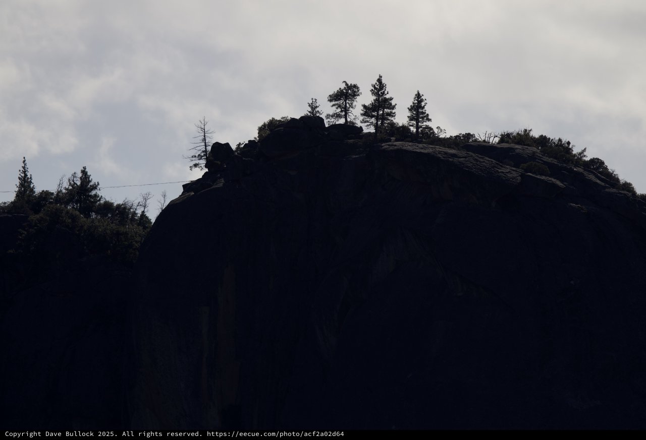 Silhouetted Rocky Outcrop with Pine Trees at Dusk