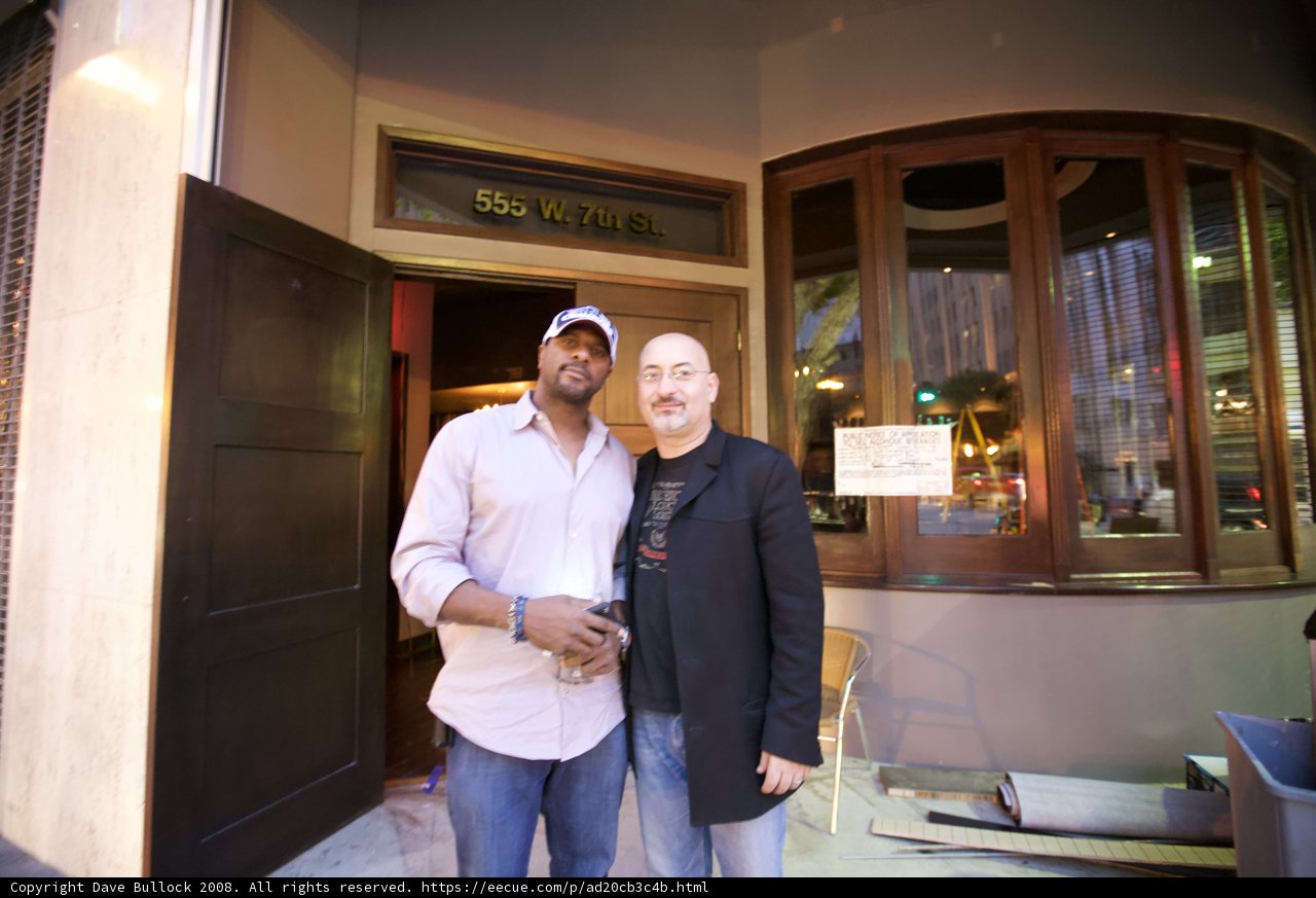 Two Men Enjoy a Meal in Front of a Cozy Restaurant