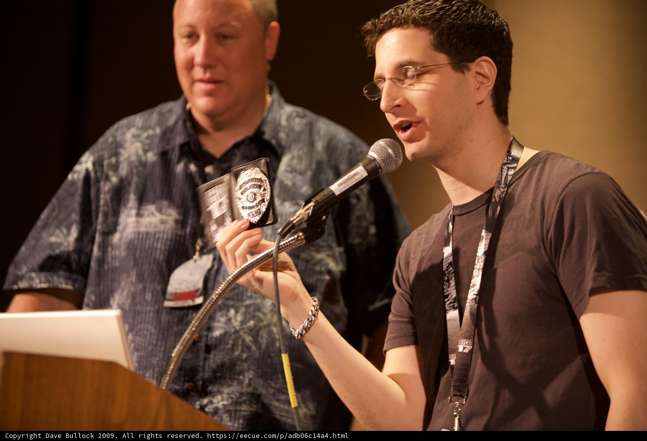 Two Men Speak at Podium with Microphones