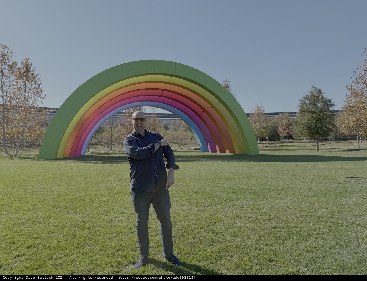 Man Posing with Large Rainbow Art Installation