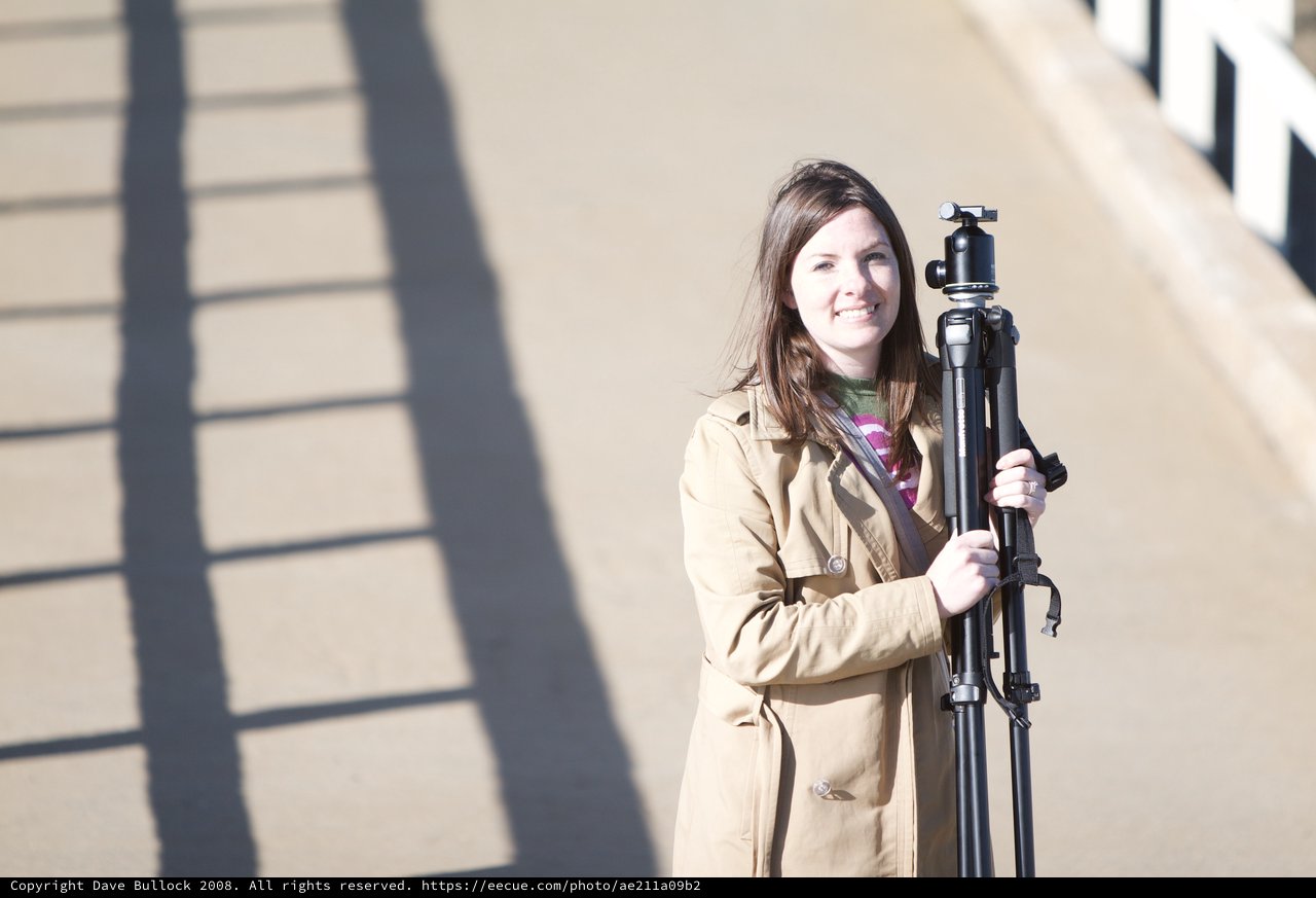 Photographer Penelope Smiling with Tripod on Bridge