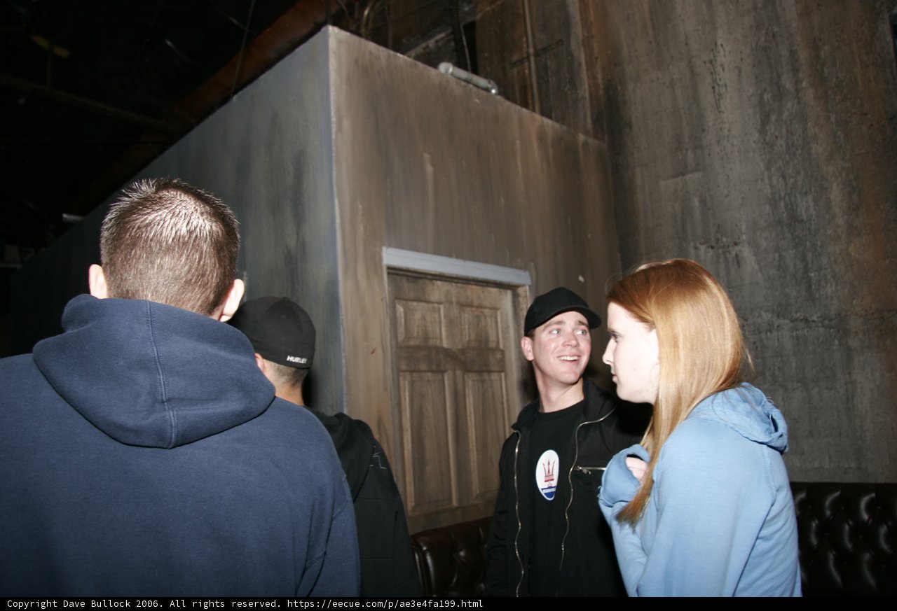 Four People Standing Outside A Door